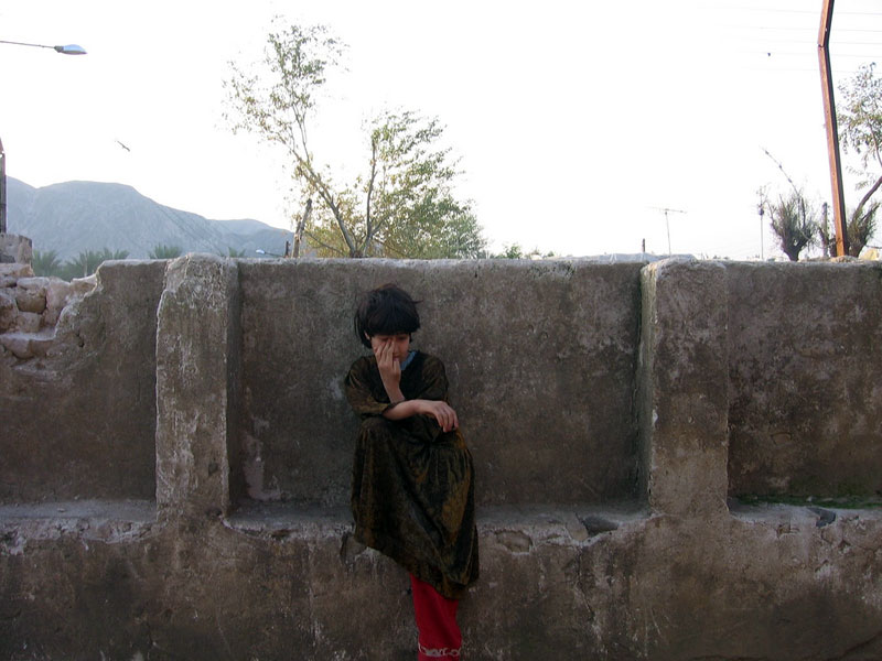 Un enfant assis contre un mur