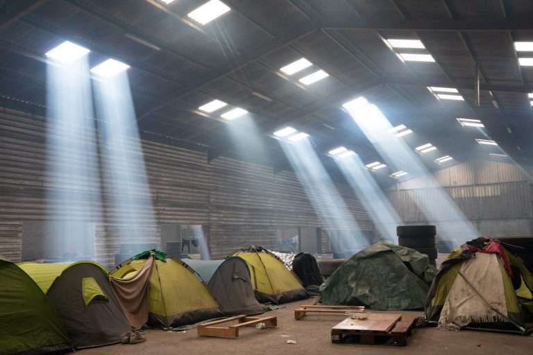 Des tentes installées dans un hangar